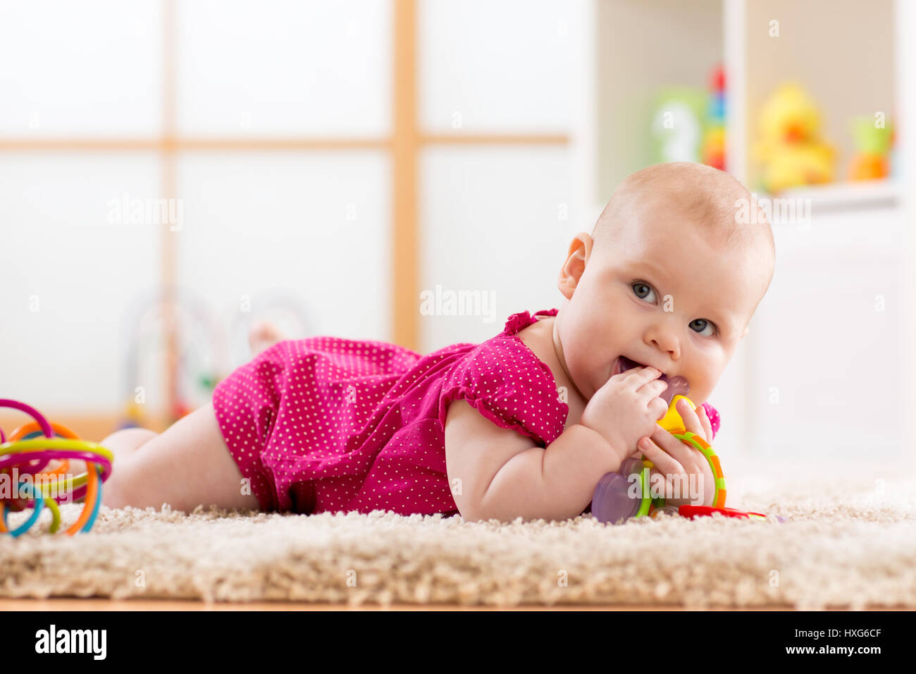 Baby masticare sul giocattolo per la dentizione Foto Stock