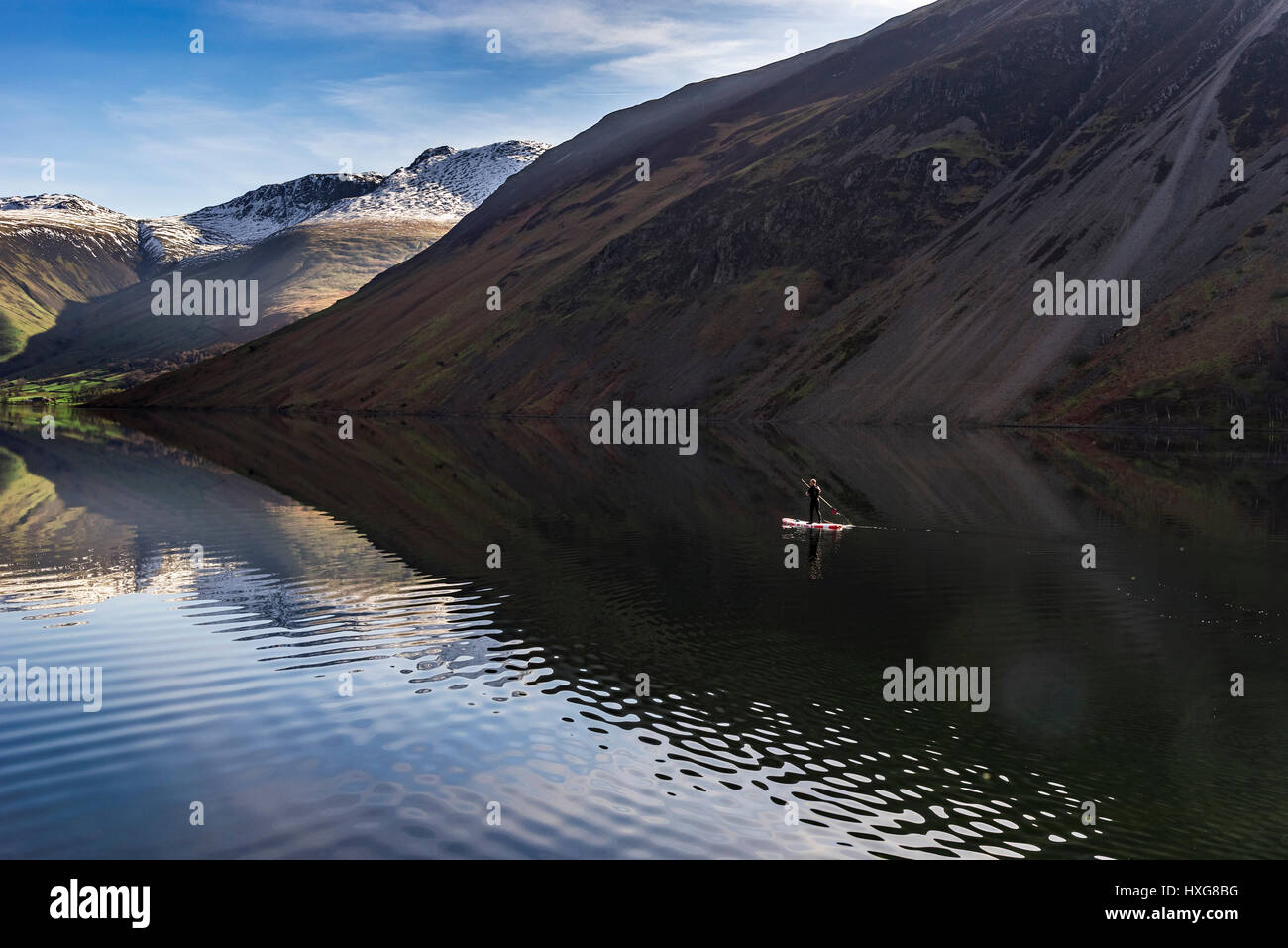 Un lone paddlebaorder o0n la flatcalm acque di Wasdale Foto Stock