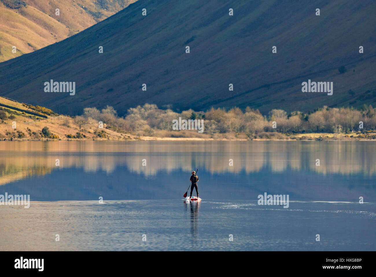 Un lone paddlebaorder sulle acque flatcalm di Wasdale Foto Stock
