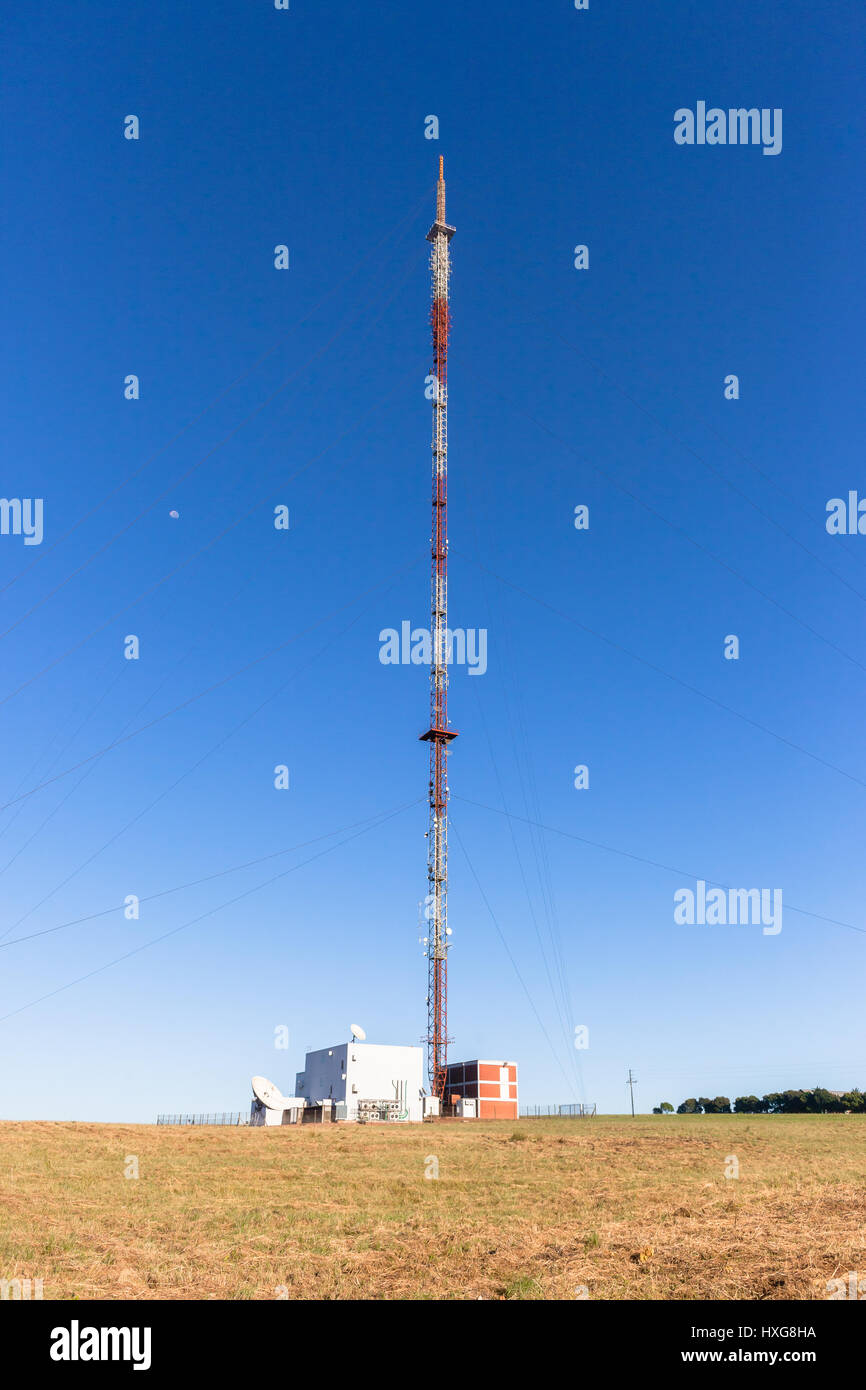 Comunicazioni torre segnale alto sulla struttura highground hilltop per radio tv per i telefoni cellulari contro il cielo blu. Foto Stock