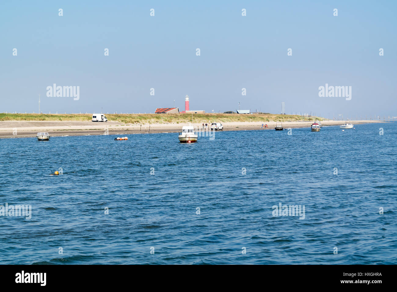 Costa del West Frisone Waddensea isola Texel con imbarcazioni da diporto , la gente e il faro di De Cocksdorp, Paesi Bassi Foto Stock
