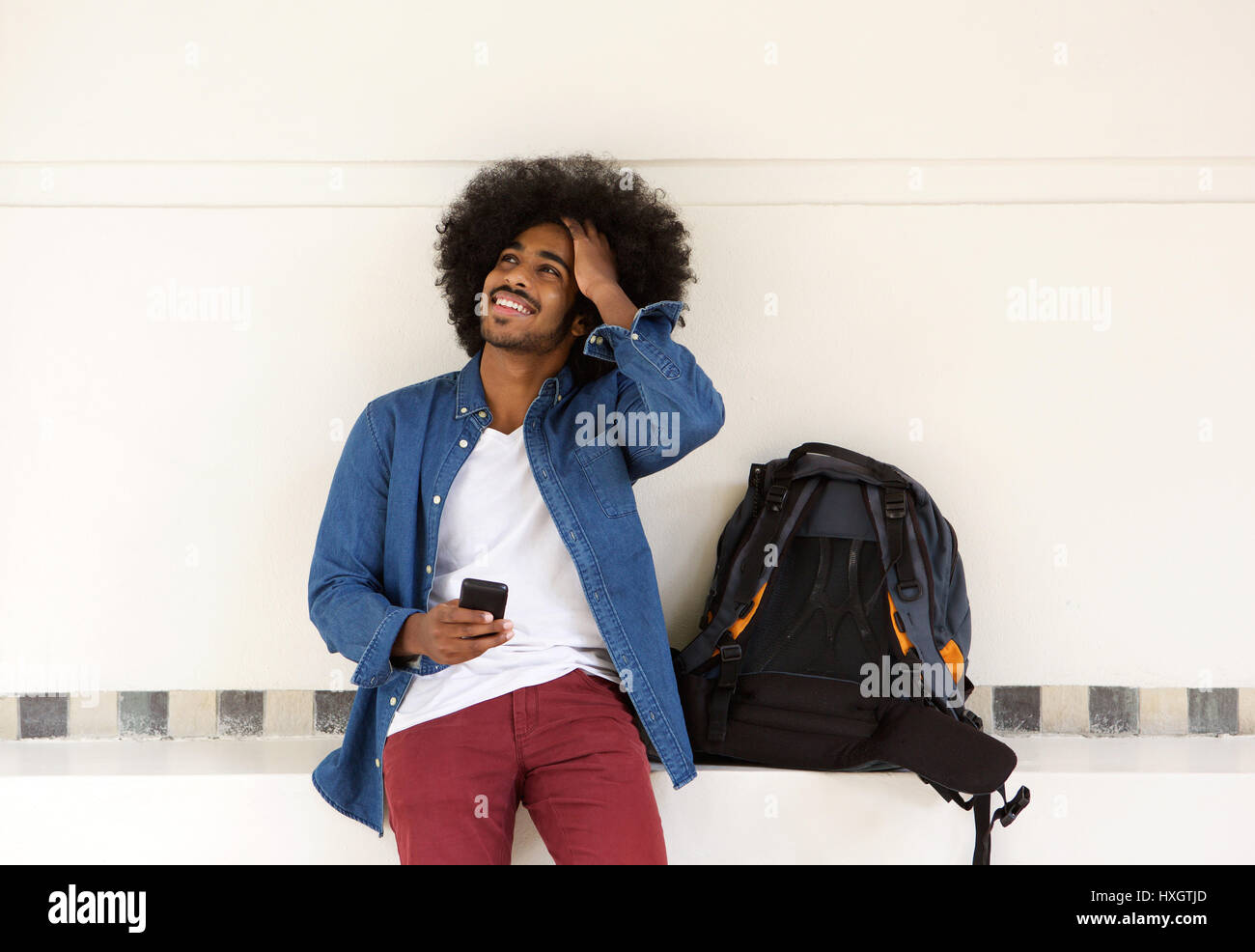 Ritratto di un fresco ragazzo di viaggio rilassante con il telefono cellulare Foto Stock