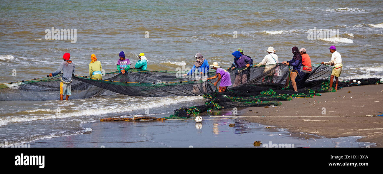 I membri di un filippino villaggio di pescatori haul nel loro seine net a Baybay Beach, Roxas City, Capiz, Panay Island, Filippine Foto Stock