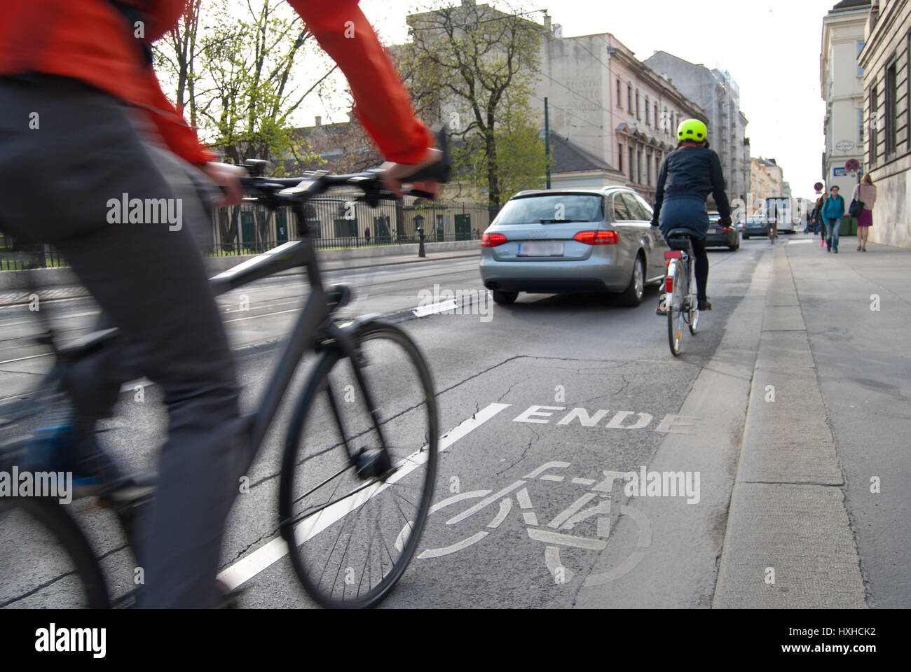 Fine di una pista ciclabile. Pericolosa situazione di conflitto su una strada trafficata. I ciclisti, automobilisti e pedoni e tram che lottano per lo spazio per i loro mezzi o Foto Stock
