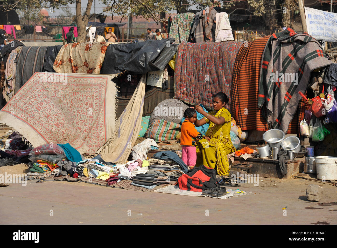 Una donna la pettinatura la sua giovane figlia di capelli appena lavati in una delle baraccopoli, New Delhi Foto Stock