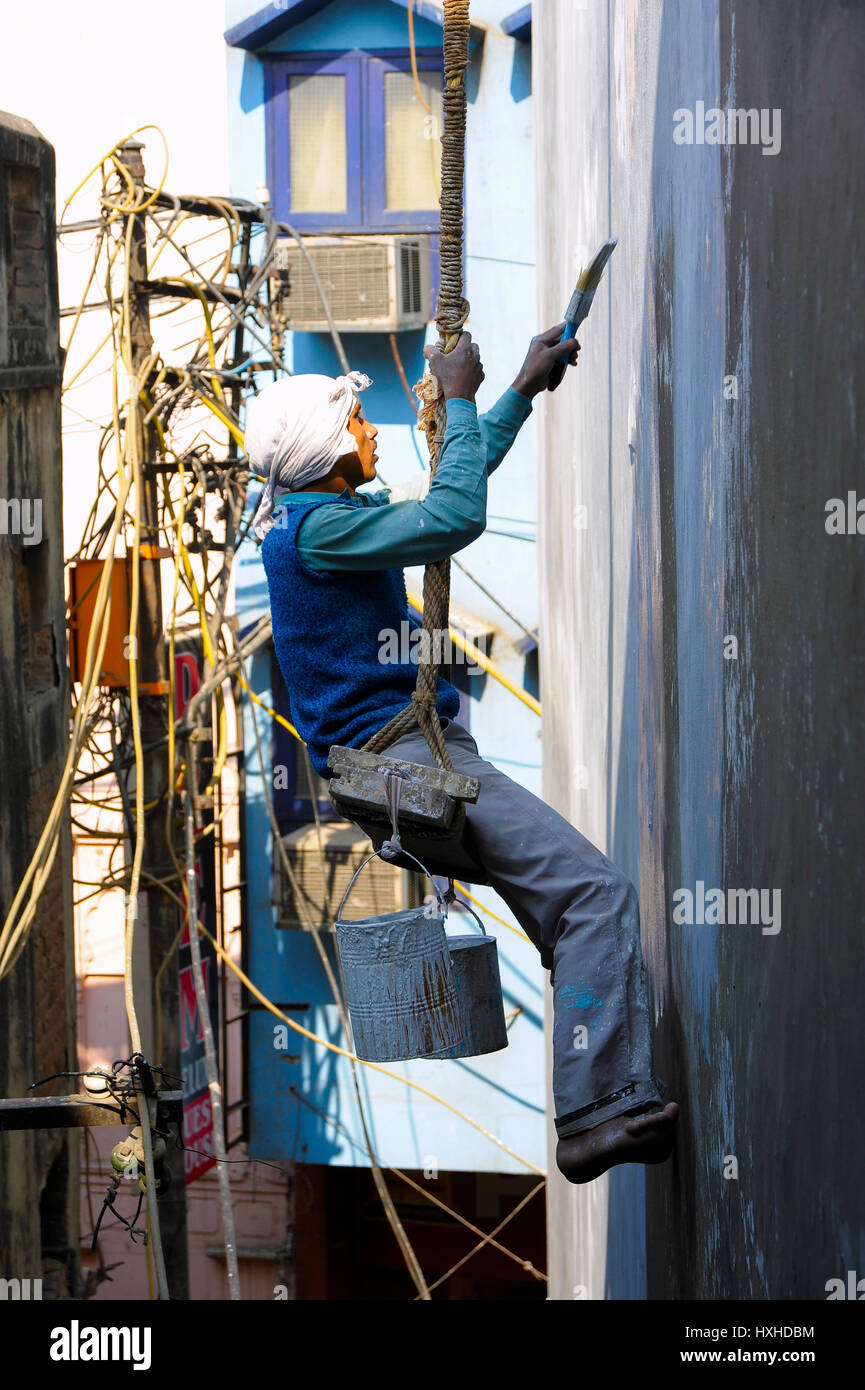 Decorator sulla puleggia della pittura di pareti esterne di un edificio di Nuova Delhi Foto Stock