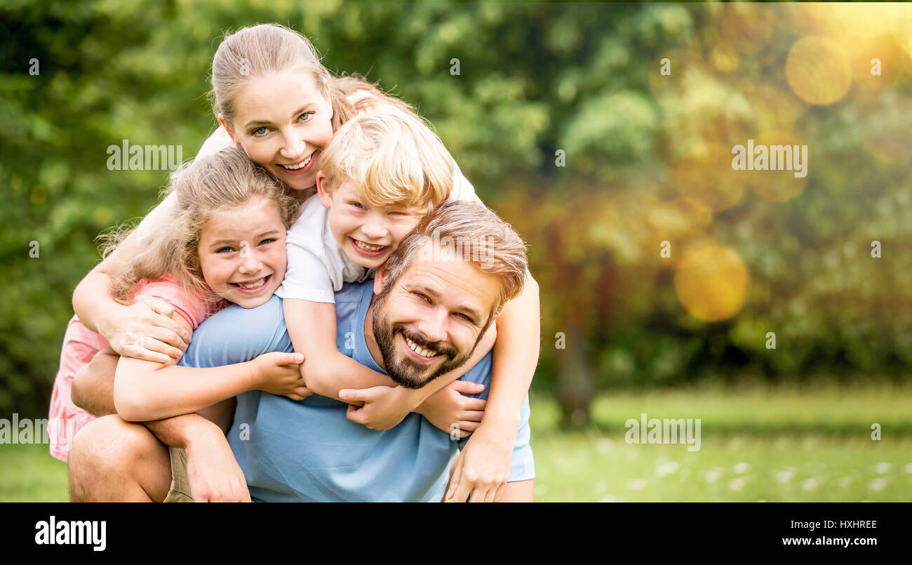 I genitori e i figli in quanto famiglia felice costeggiata in primavera Foto Stock