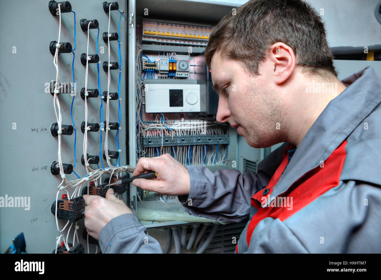 San Pietroburgo, Russia - Marzo 5, 2013: Ingegnere meccanico di fare l'aggiornamento degli equipaggiamenti quadro elettrico. Foto Stock