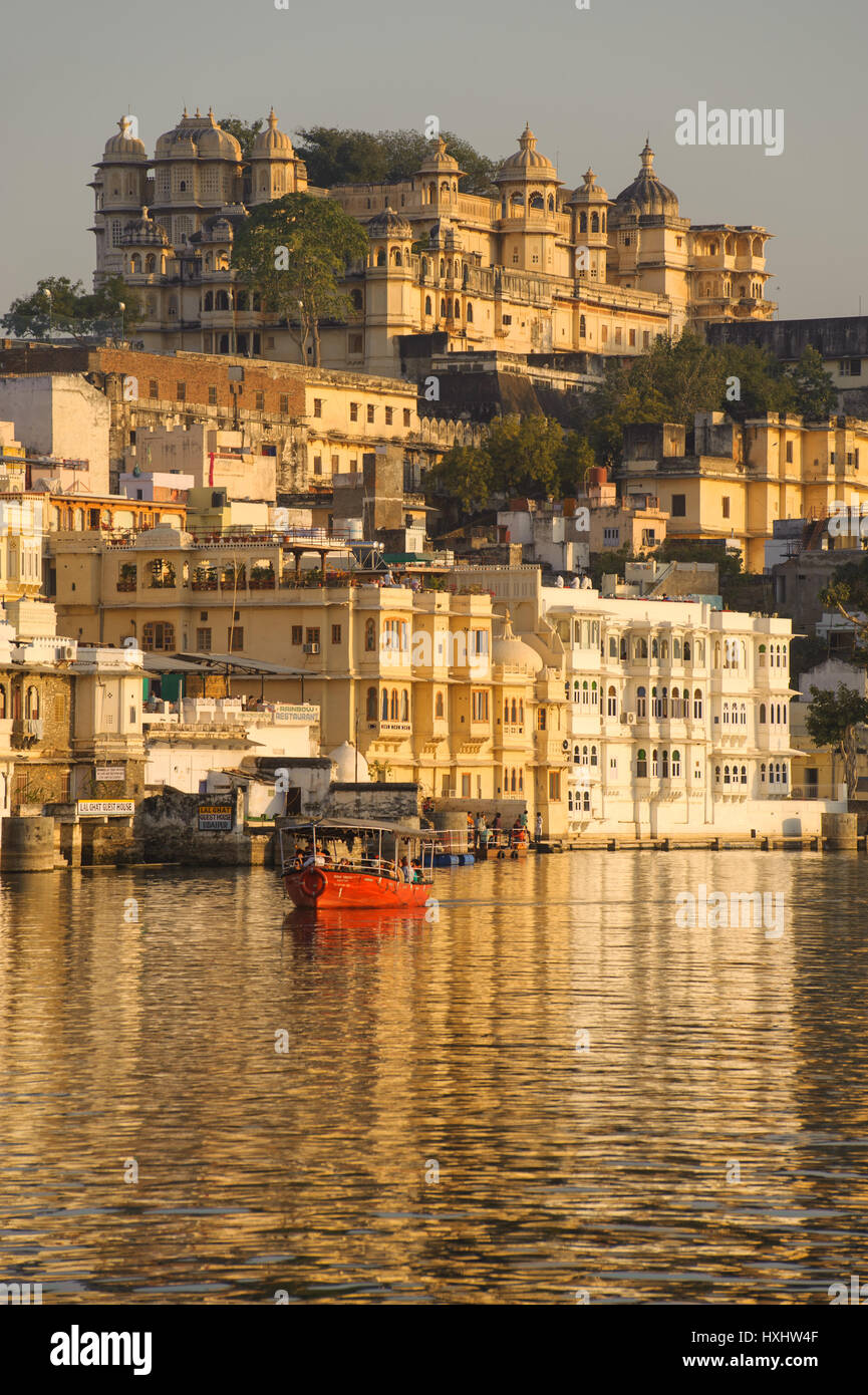 Una barca che porta i visitatori su Udaipur il Lago Pichola, vista palazzo di città come sfondo Foto Stock