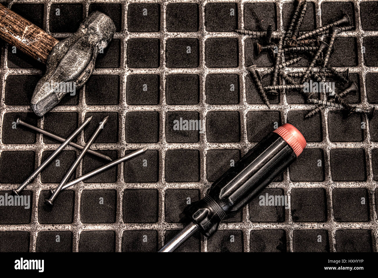 Cacciavite e viti su sfondo di legno Foto Stock