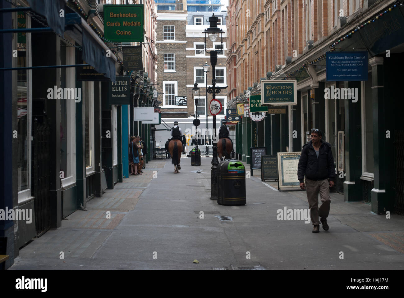 Il Cecil Court di Londra che è stato la fonte di ispirazione per Diagon Alley di J K Rowling Harry Potter books con due cavalli della polizia a distanza Foto Stock