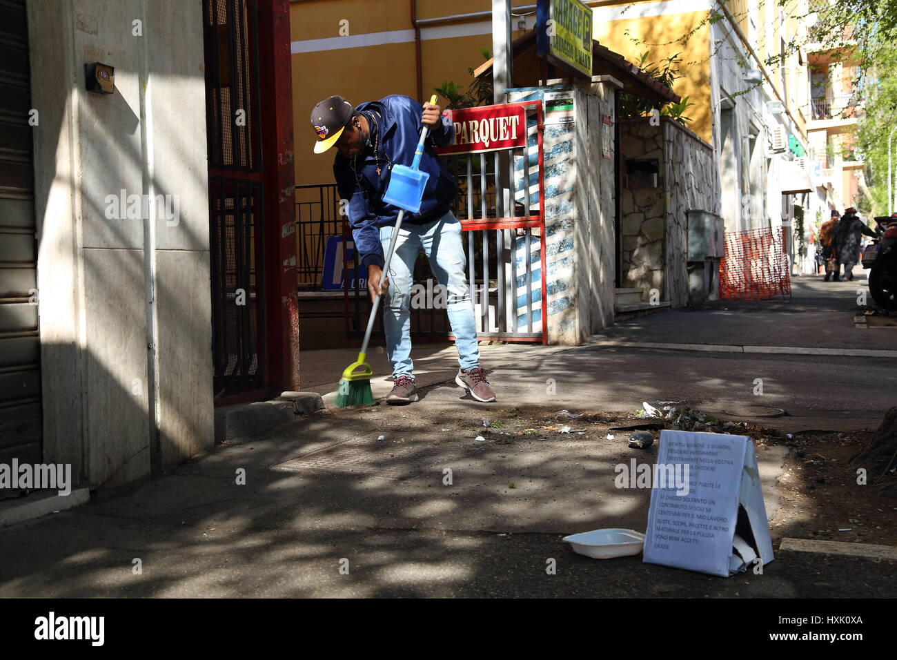 Roma, Italia. 28 Mar, 2017. Alcuni migranti a Roma stanno iniziando ad organizzarsi in attuazione del lavoro socialmente utile come la pulizia dei marciapiedi, rimuovere le erbacce e potare le aiuole di fiori. Credito: Matteo Nardone/Pacific Press/Alamy Live News Foto Stock