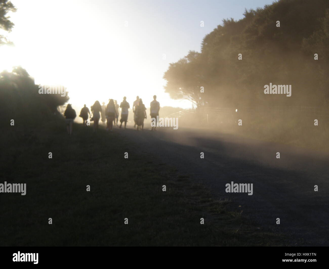 Silhouette di un gruppo di persone nel paesaggio a camminare nella luce Foto Stock