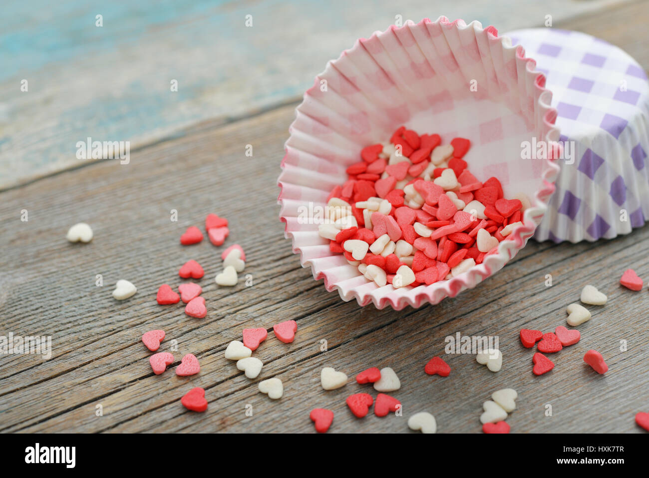 Colore candy cuori con cupcake casi su sfondo di legno Foto Stock