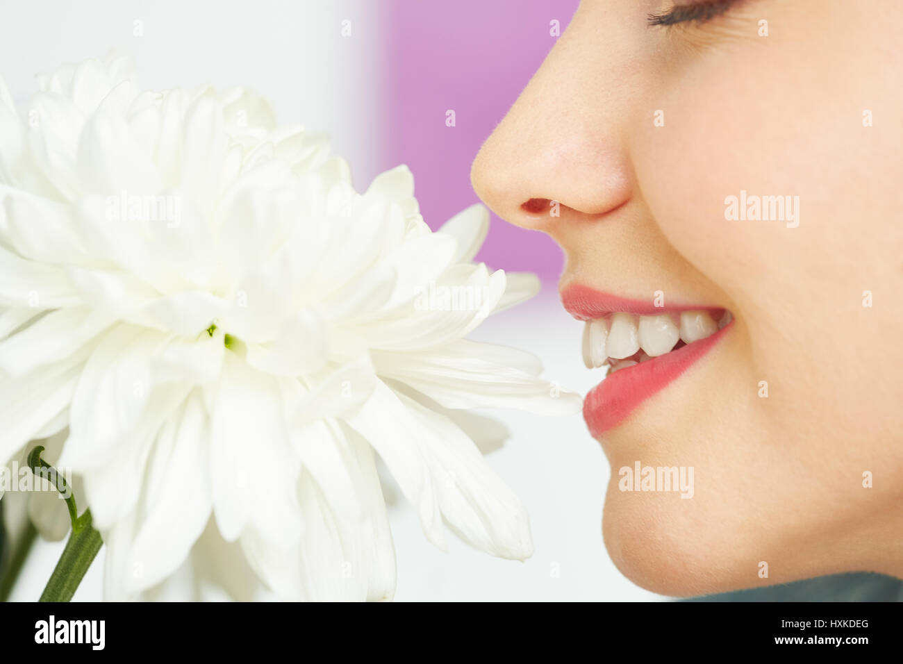 Donna sorridente godendo di profumo di fiori Foto Stock