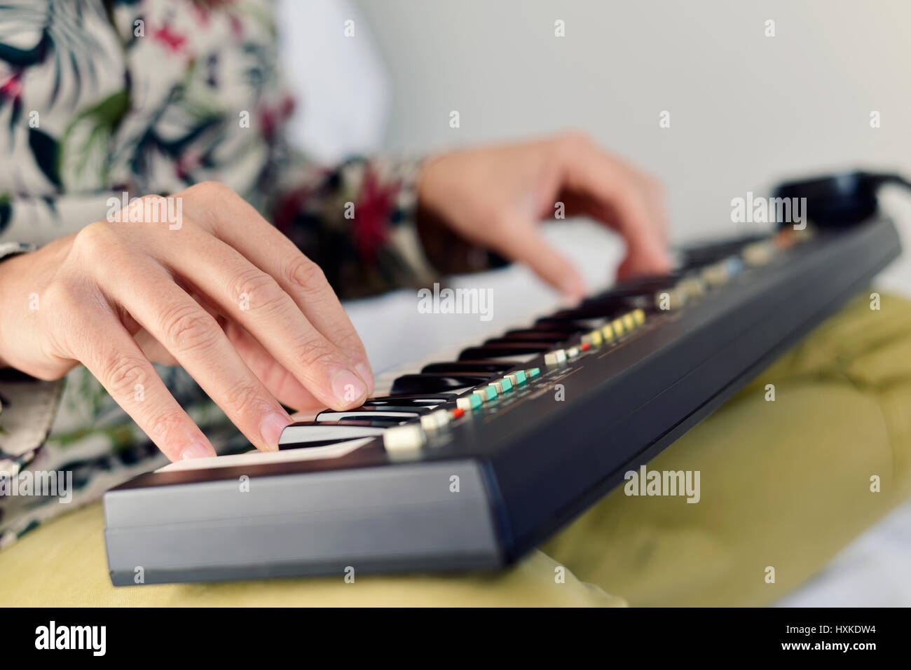 Primo piano di un giovane uomo caucasico giocando un portatile tastiera elettronica Foto Stock