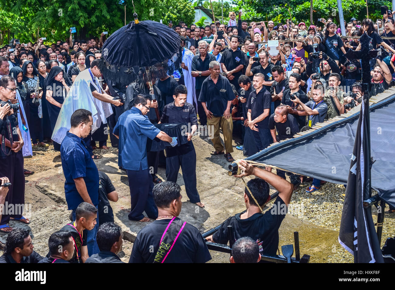 Anziani e funzionari che trasportano una scatola di legno contenente la statua di Gesù bambino su una barca, durante la commemorazione del Venerdì Santo a Larantuka, Indonesia. Foto Stock