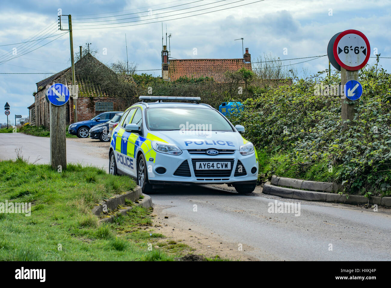 Pattuglia di polizia aziona attraverso una moderazione del traffico misurare Norfolk. Foto Stock
