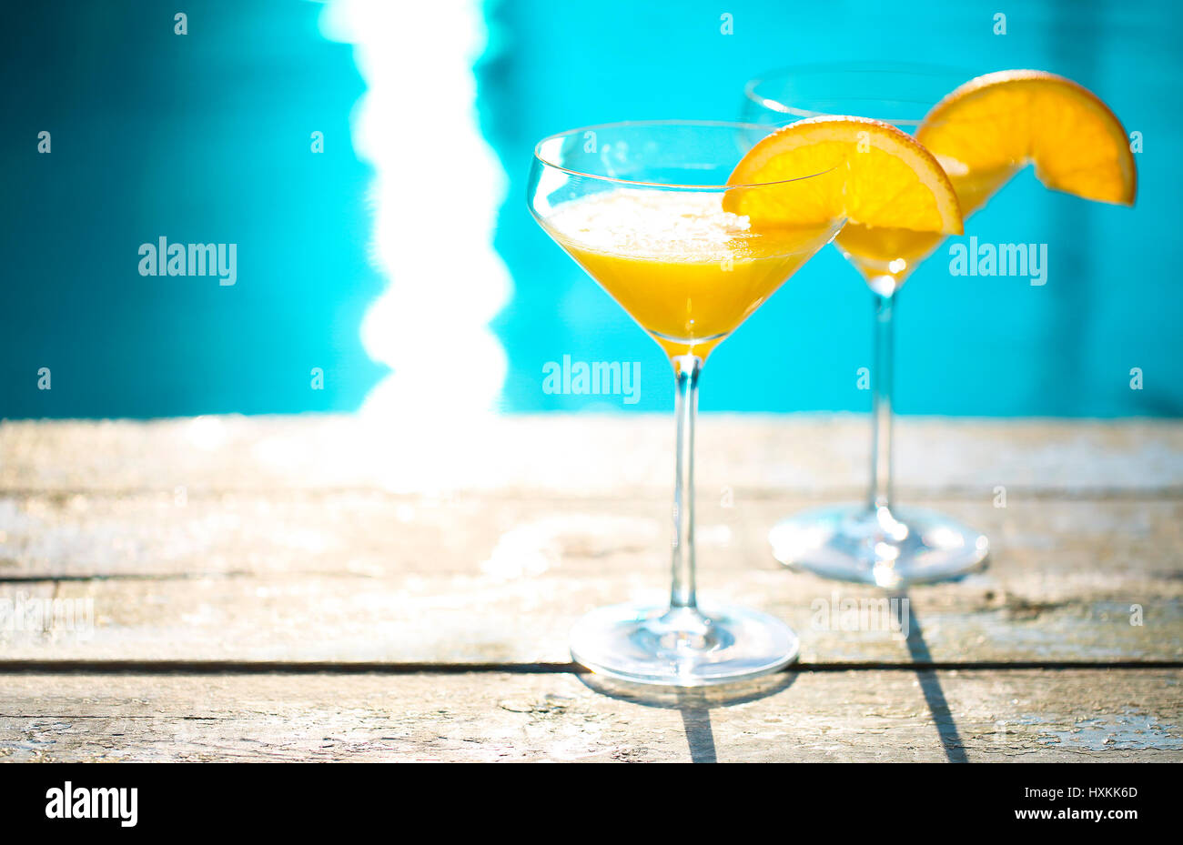 Bicchieri di champagne con fetta di arancia. Cocktail di mimosa. Summer party in piscina Foto Stock
