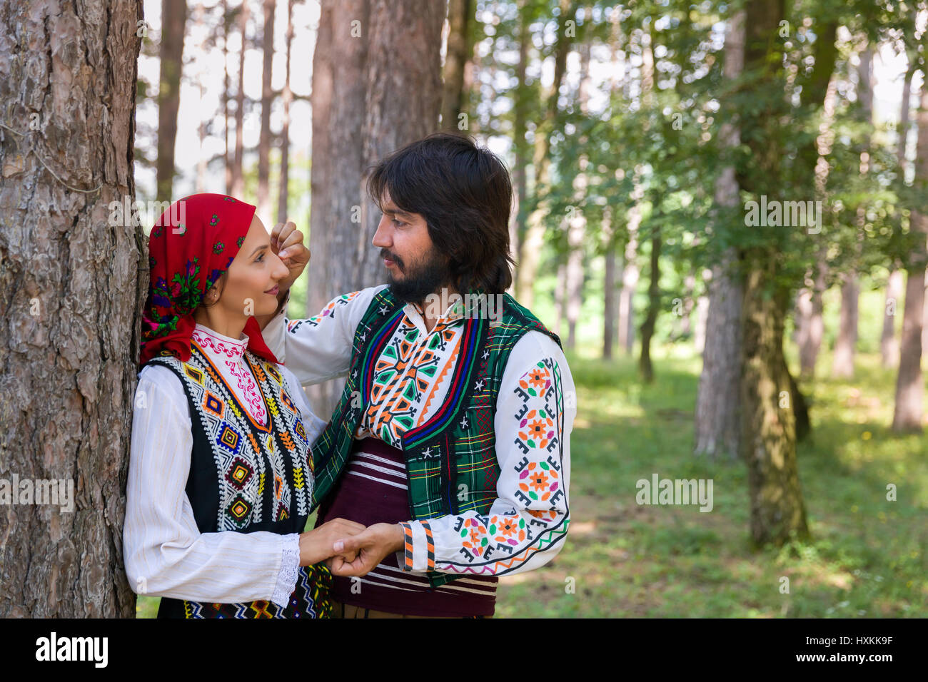 Coppia romantica in posa di una foresta indossando il tradizionale abbigliamento bulgaro Foto Stock