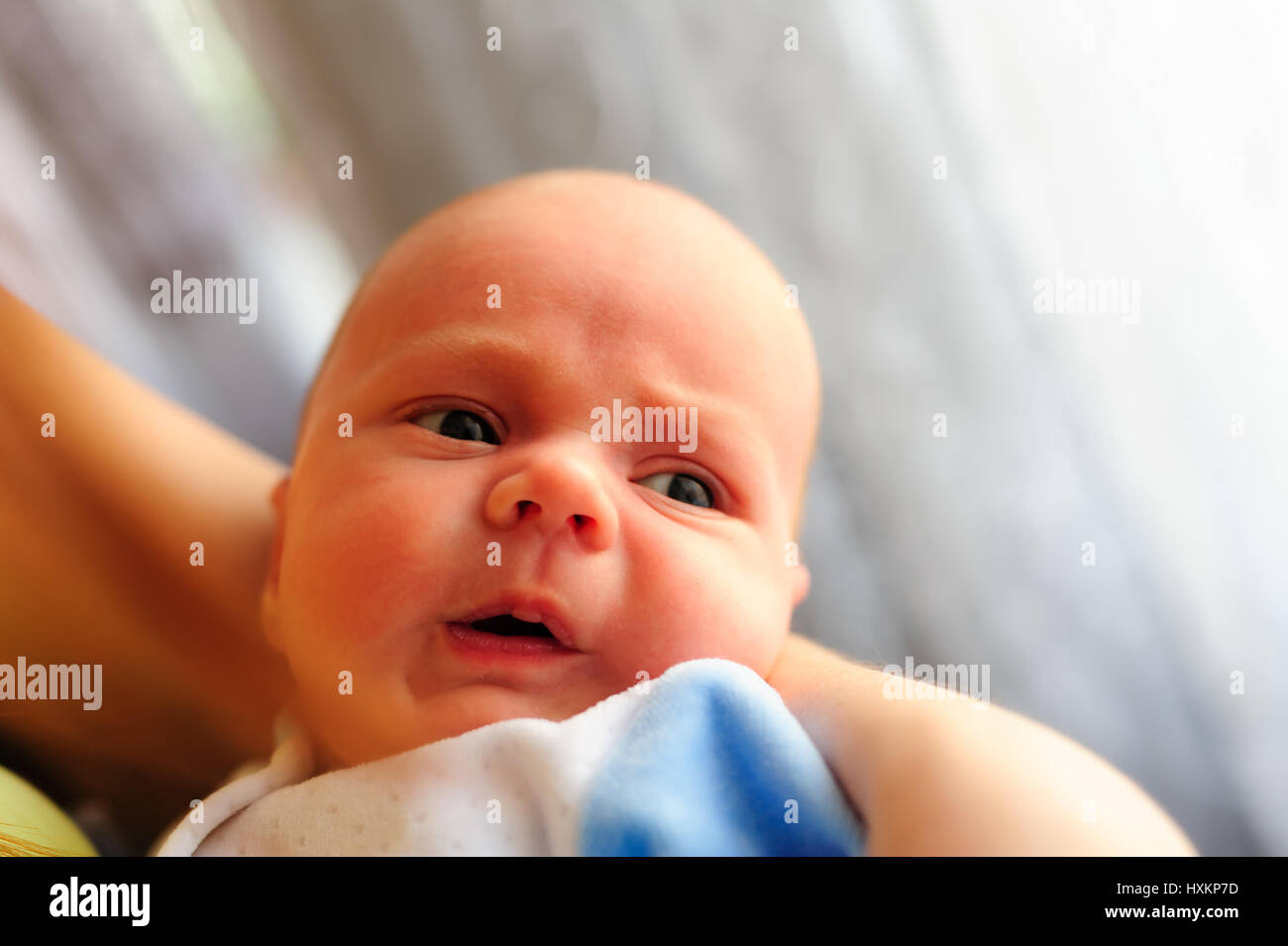 Carino Baby girl produce un divertente faccia ricalcato sulle madri mano Foto Stock