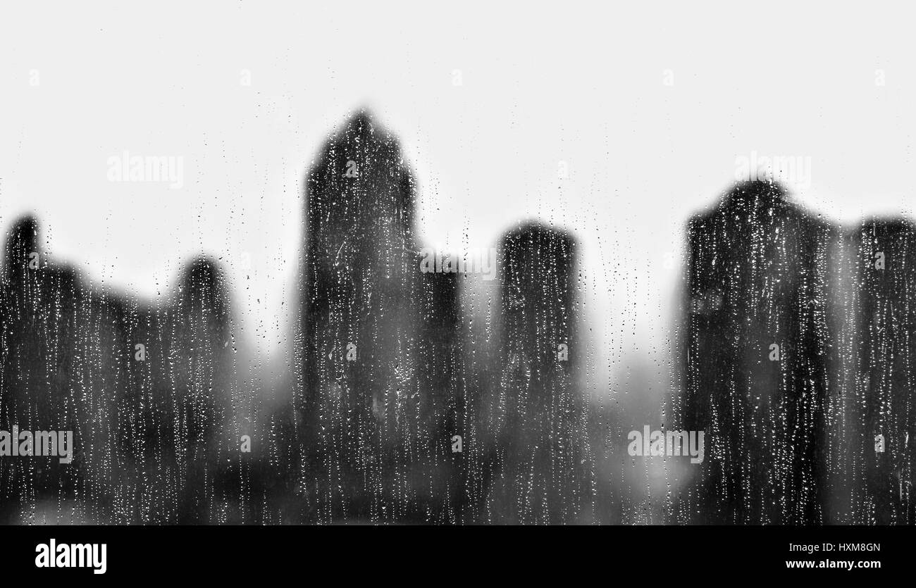 Il fuori fuoco tenebre di una skyline della città sotto la pioggia Foto Stock