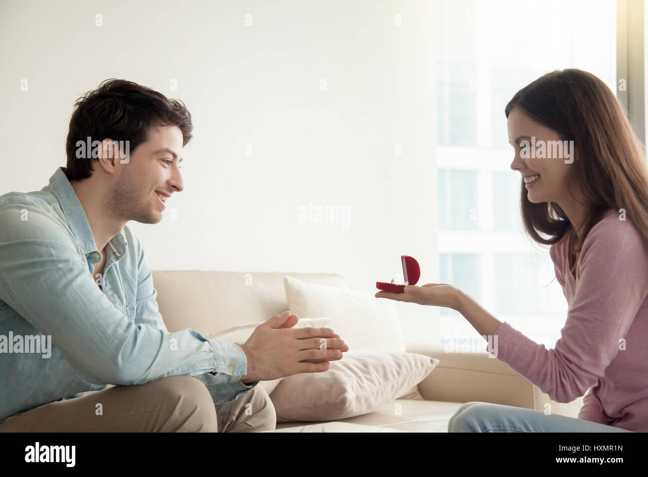 Giovane donna dando anello di fidanzamento, proponendo il fidanzato di sposare Foto Stock