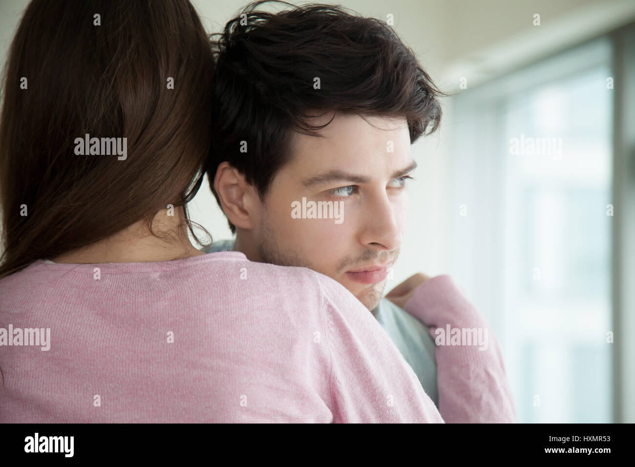 Coppia giovane costeggiata, donna abbracciando consolante uomo, moglie conso Foto Stock