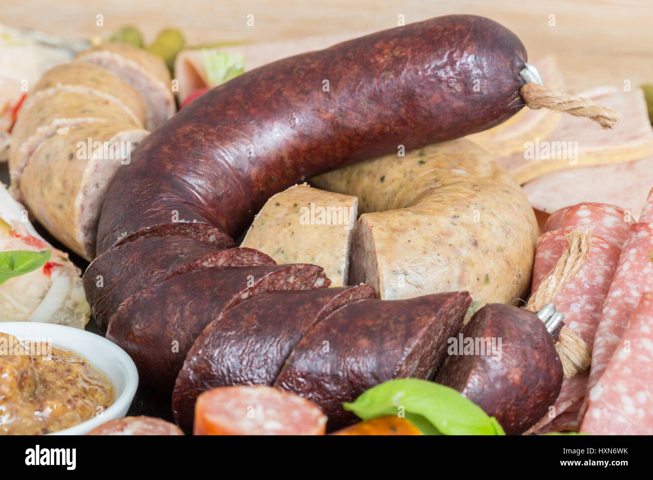 Piastra di salsiccia di variazione su un tavolo di legno. Foto Stock