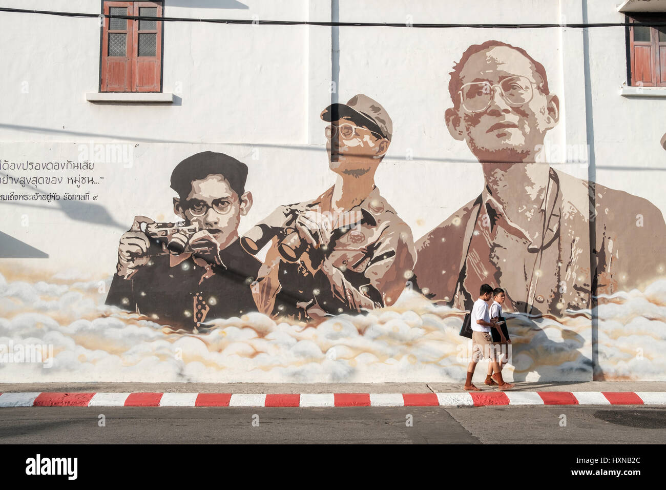 Thai scolari in Phuket Città Vecchia passano un murale in ricordo del Re Bhumibol Adulyadej. Come la Tailandia piangono il re i monumenti in ricordo del Foto Stock