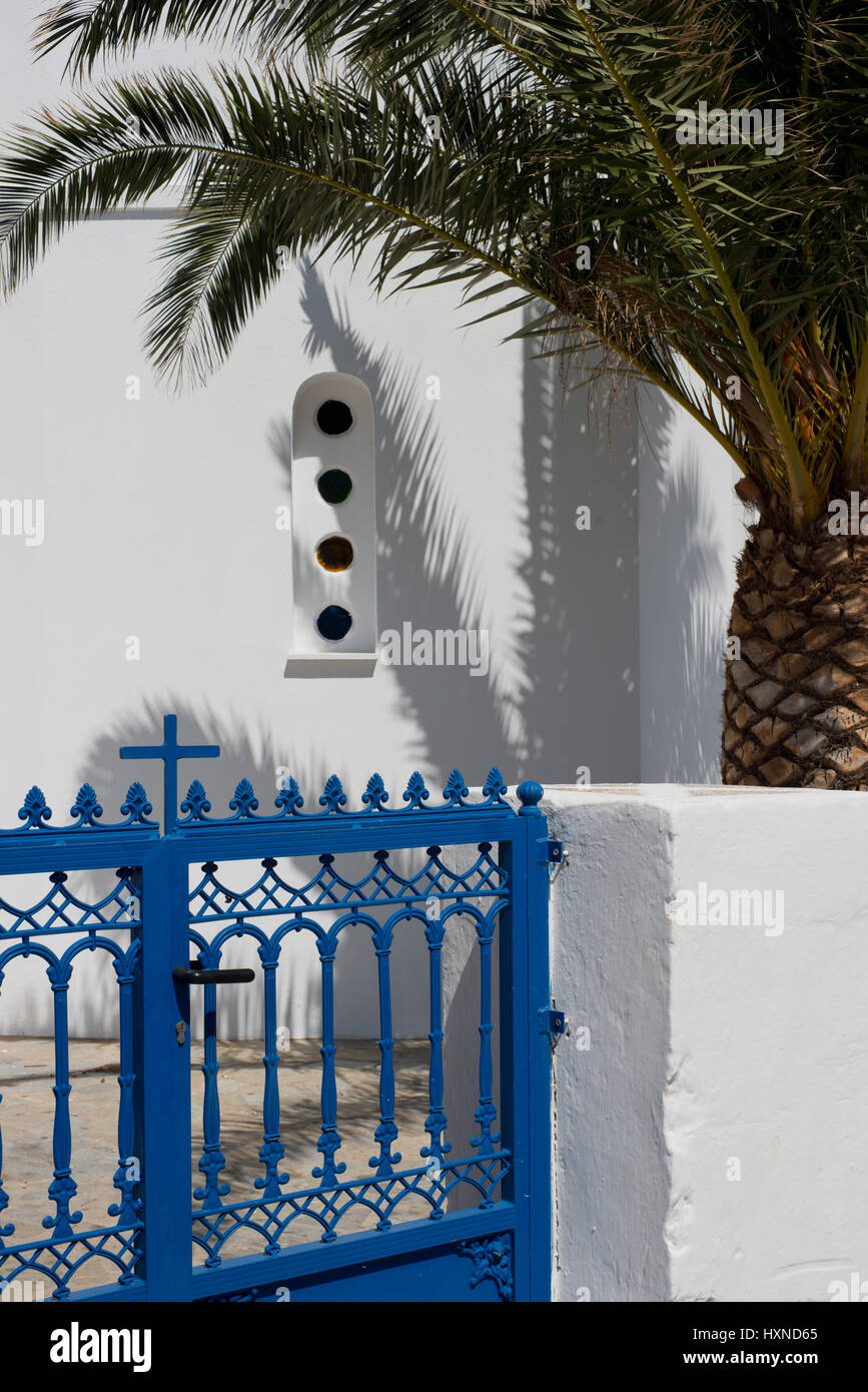 Weiße Kirche mit blauem Eisentor und Palme auf Iraklia Insel, kleine Kykladen, Griechenland Foto Stock