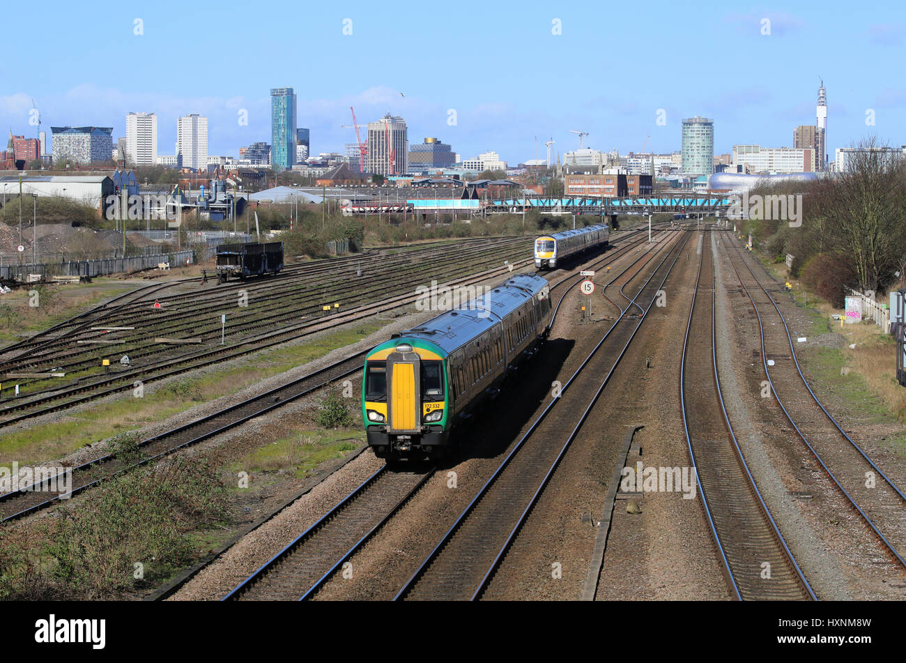 Treni passeggeri servizi voce dentro e fuori del centro cittadino di Birmingham, West Midlands, England, Regno Unito e una vista del centro della città skyline. Foto Stock