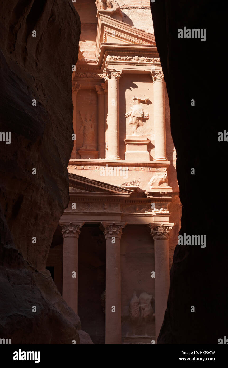 Giordania: uno scorcio di Al-Khazneh, il Tesoro, uno dei più famosi templi in Petra visti attraverso le rocce di Siq, l'entrata principale canyon Foto Stock