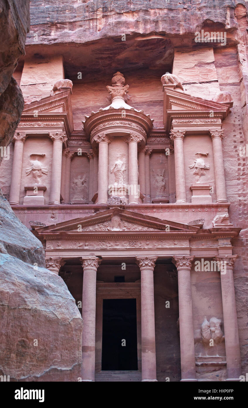 Giordania: la facciata di Al-Khazneh, il Tesoro, uno dei più famosi templi in Petra visti attraverso le rocce di Siq, l'entrata principale canyon Foto Stock