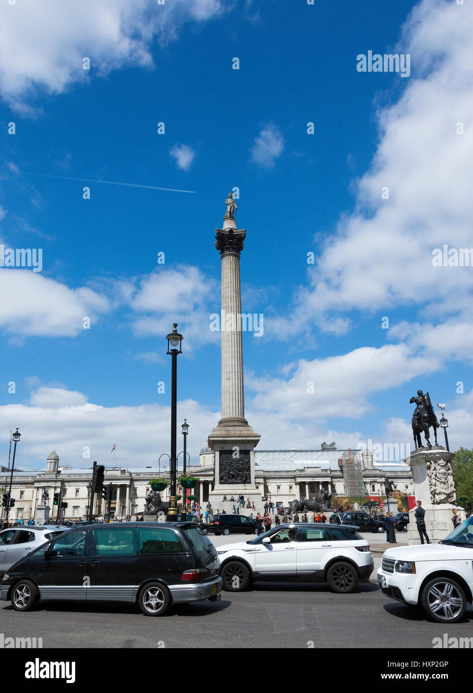 Il traffico intorno alla guida di Nelson's colonna in Trafalgar Square a Londra, Inghilterra, Regno Unito Foto Stock