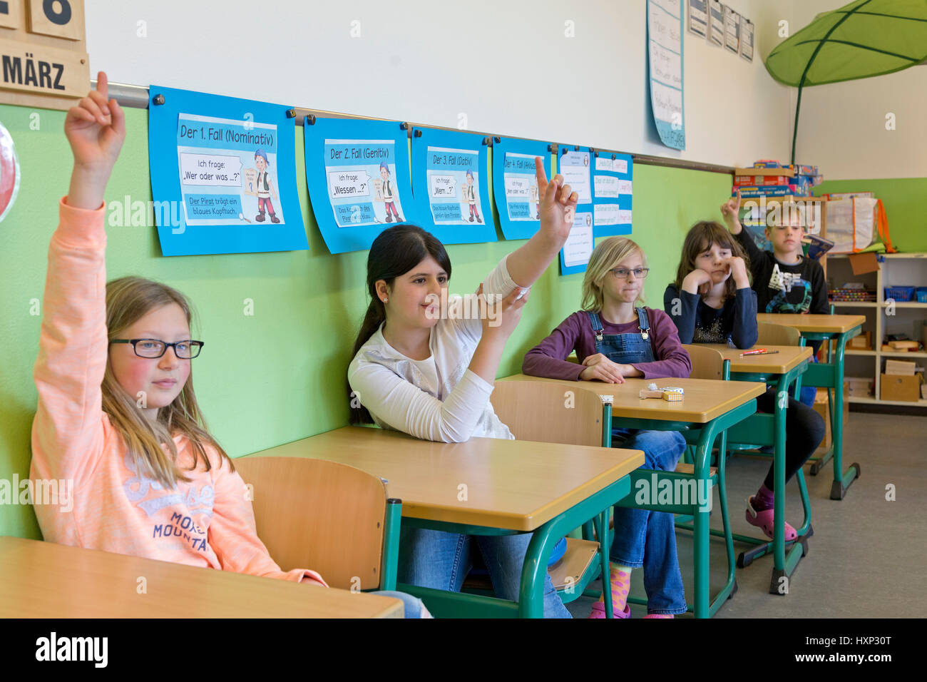 I bambini ad alzare la mano presso la scuola primaria Foto Stock