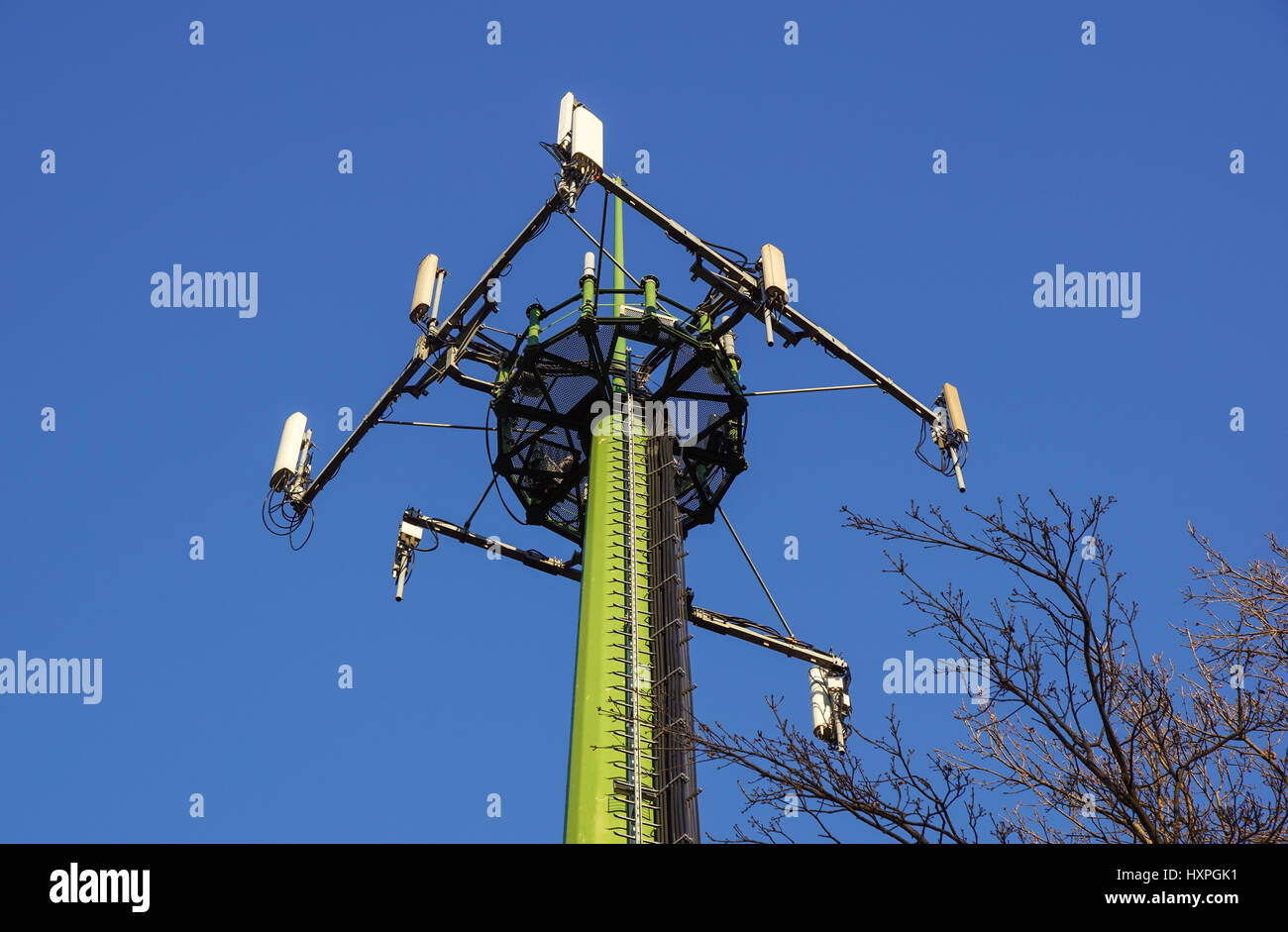 Acciaio torre di telecomunicazione con le antenne sul cielo blu e alberi Foto Stock