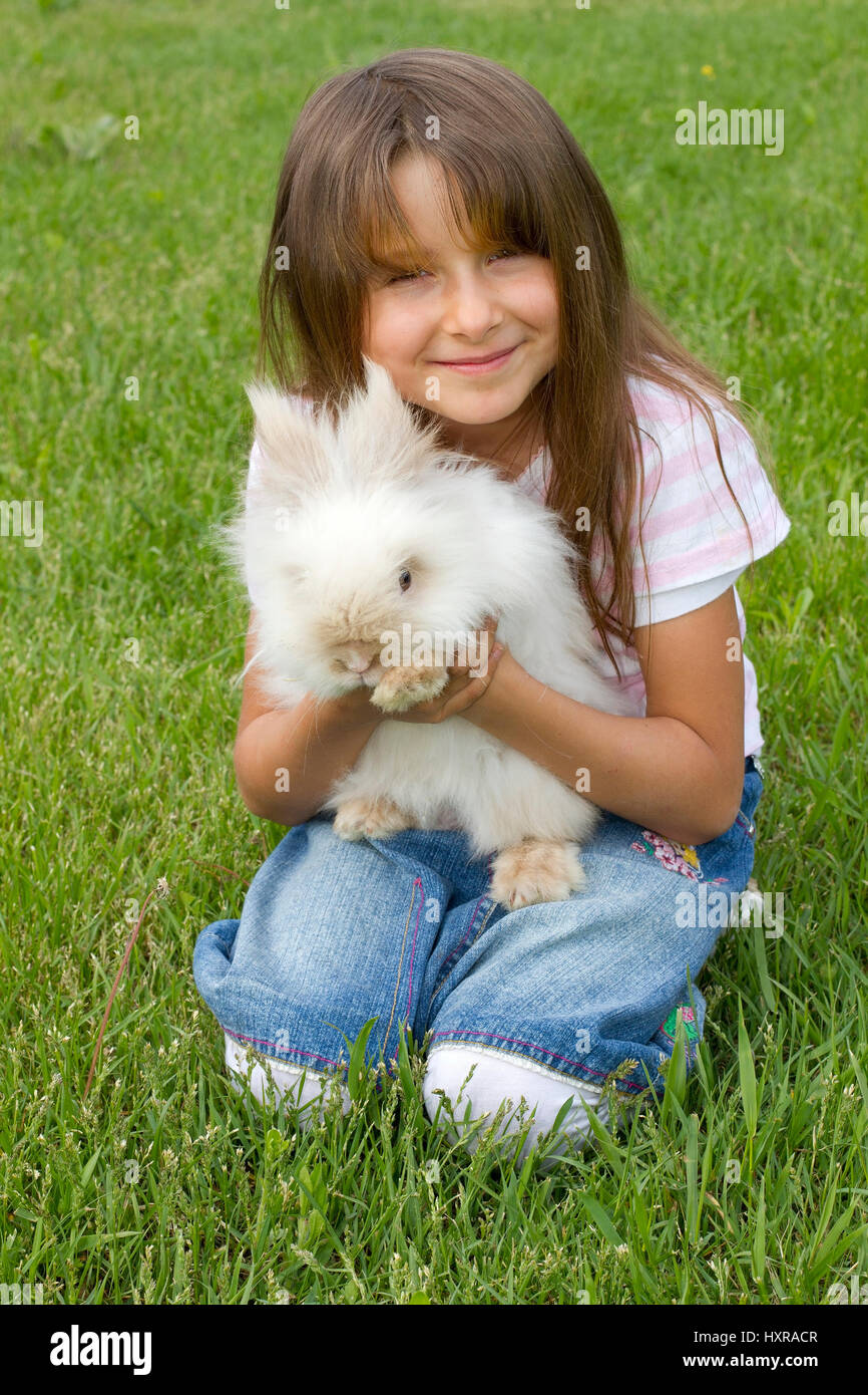 Bambina di sette anni con Teddy's pigmeo di coniglio, siebenjähriges Mädchen mit Teddyzwergkaninchen Foto Stock