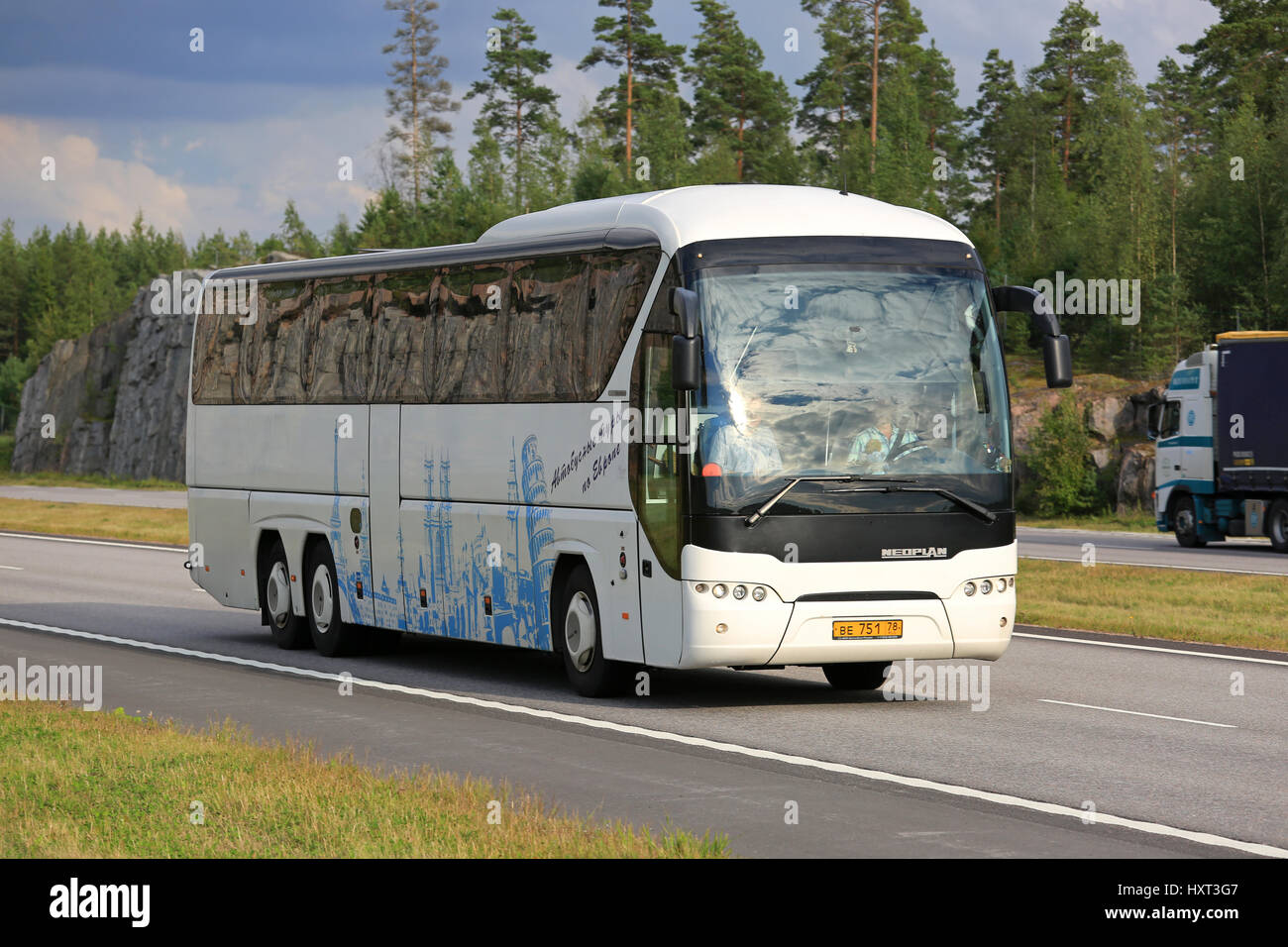 PAIMIO, Finlandia - Agosto 19, 2016: Bianco Neoplan Tourliner pullman si muove lungo il traffico autostradale nel paesaggio rurale del sud della Finlandia. Foto Stock
