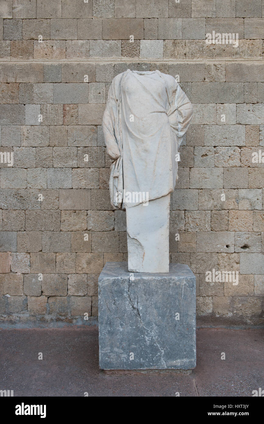 Statua romana da marmo bianco nel Museo Archeologico di Rodi nella parte anteriore del muro di pietra, la città medievale di Rodi, Dodecanneso, Grecia Foto Stock