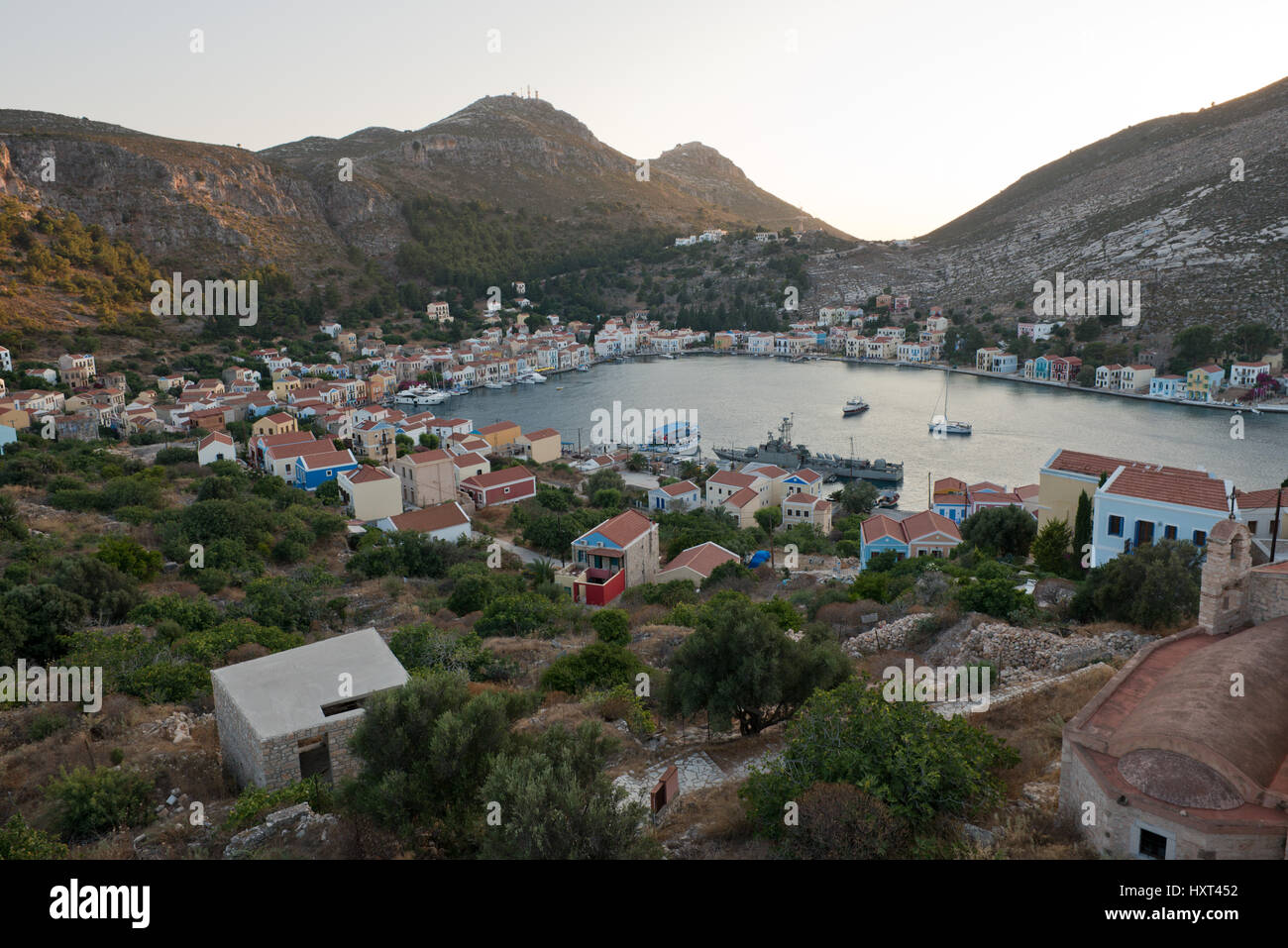 Östlicher Blick auf Hafen, Bucht mit bunten Häusern und kahlen Hügeln, Insel Kastellorizo, Dodekanes, Griechenland Foto Stock