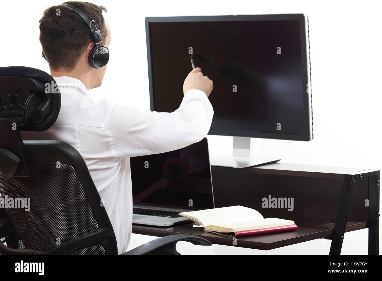Uomo al lavoro su computer in ufficio vista dal retro Foto Stock