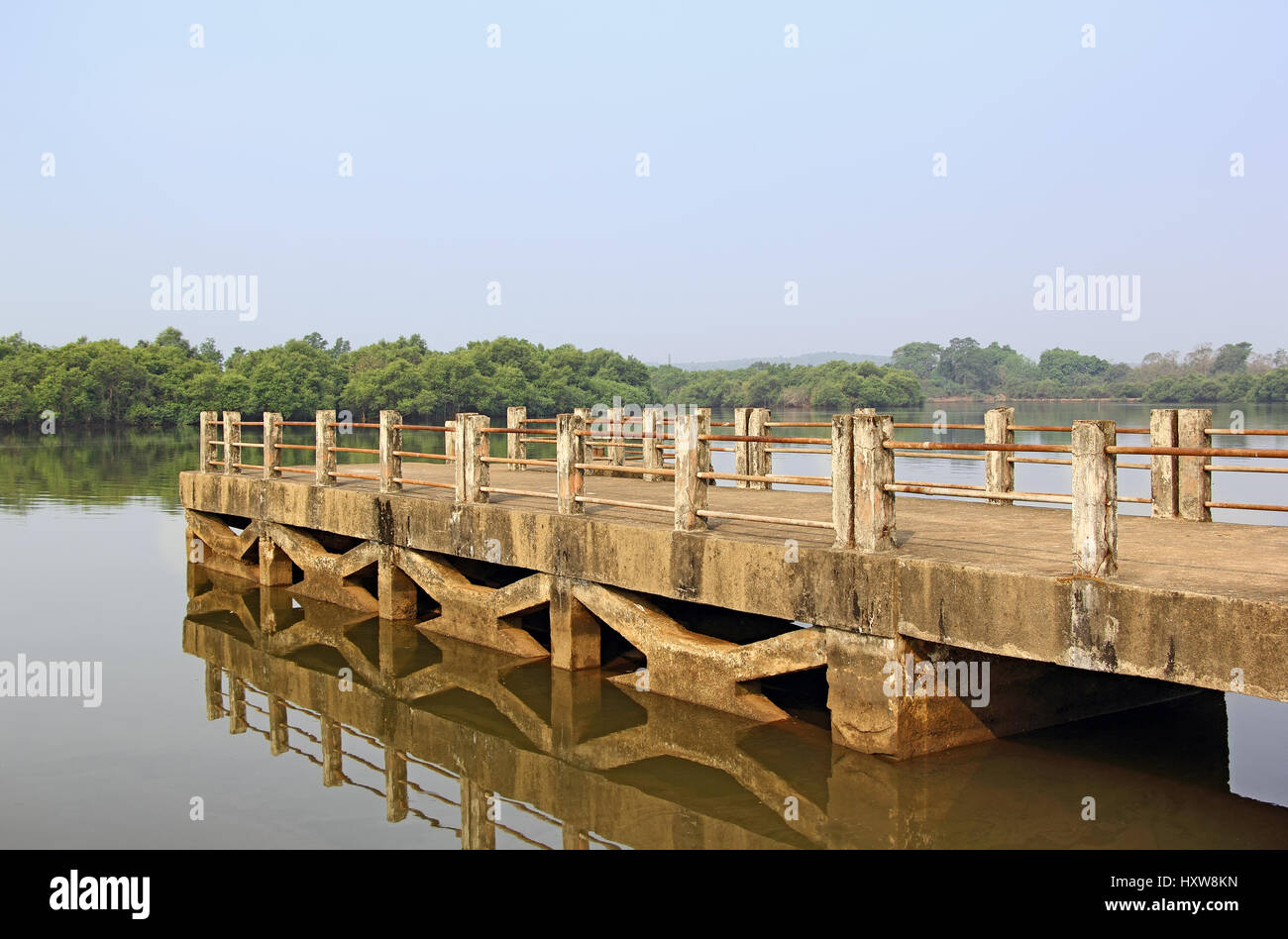 Sarmanas pittoresco molo riflettendo su clam acqua nel fiume Mandovi in Goa, India Foto Stock