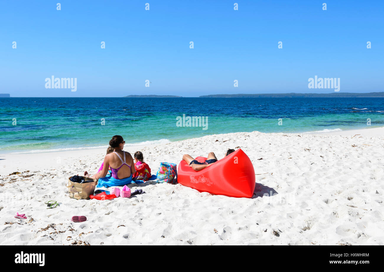 La famiglia in un momento di relax a Hyams Beach, un popolare spettacolare tratto di Jervis Bay con sabbia bianca e finissima, Nuovo Galles del Sud, NSW, Australia Foto Stock