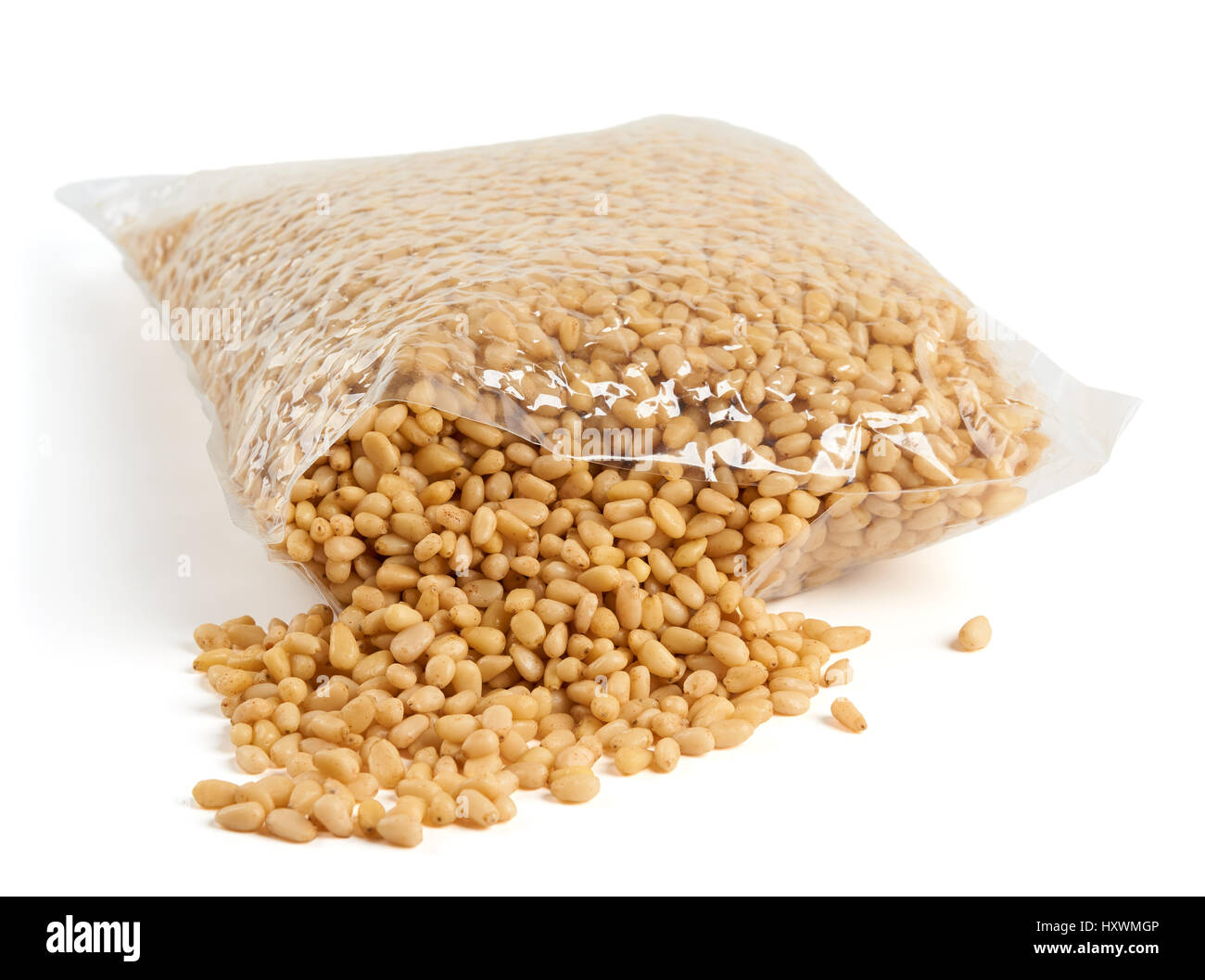 I pinoli in aperto imballaggio trasparente su bianco Foto Stock
