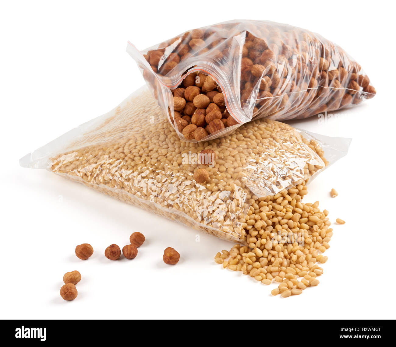 Le nocciole e i pinoli in aperto imballaggio trasparente su bianco Foto Stock