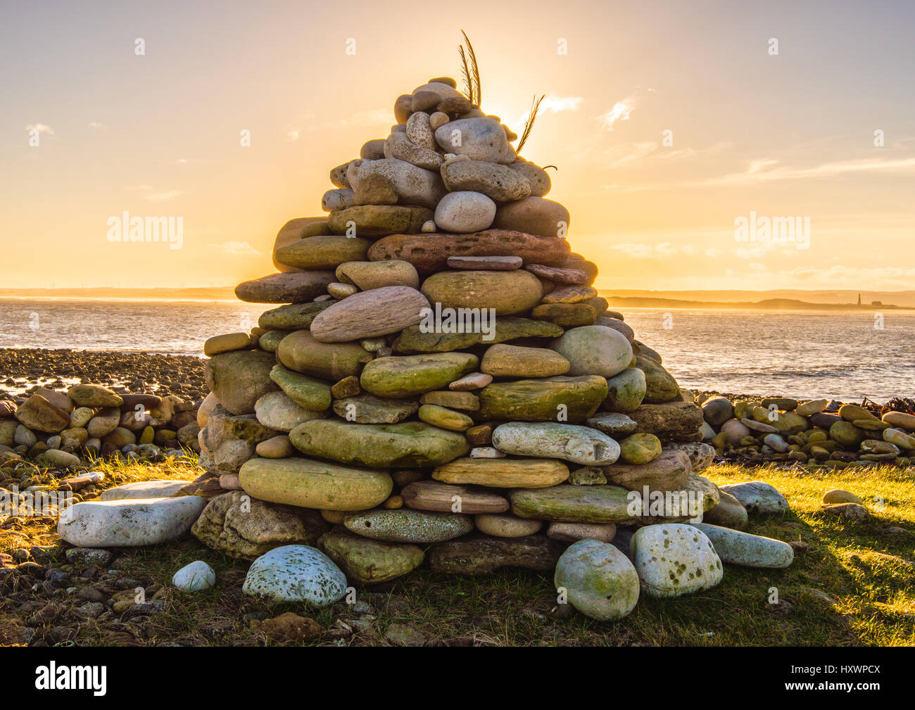 Il tumulo di pietra durante il tramonto su lindisfarne northumberland, Inghilterra Foto Stock