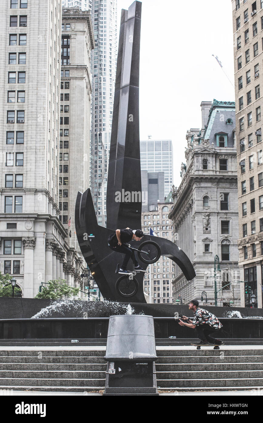 Un guidatore di skateboard è catturare il suo amico facendo trucchi su una bici BMX in New York City, Stati Uniti d'America. Foto Stock Un guidatore di skateboard è catturare il suo amico facendo trucchi su una bici BMX in New York City, Stati Uniti d'America. Foto Stock