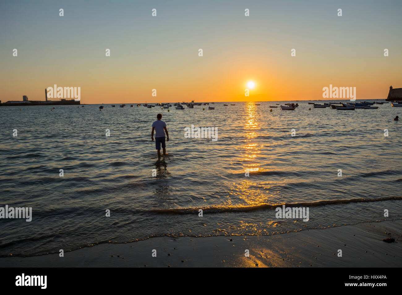 Ragazzo giovane leccare i piedi sulla spiaggia al tramonto Foto stock -  Alamy