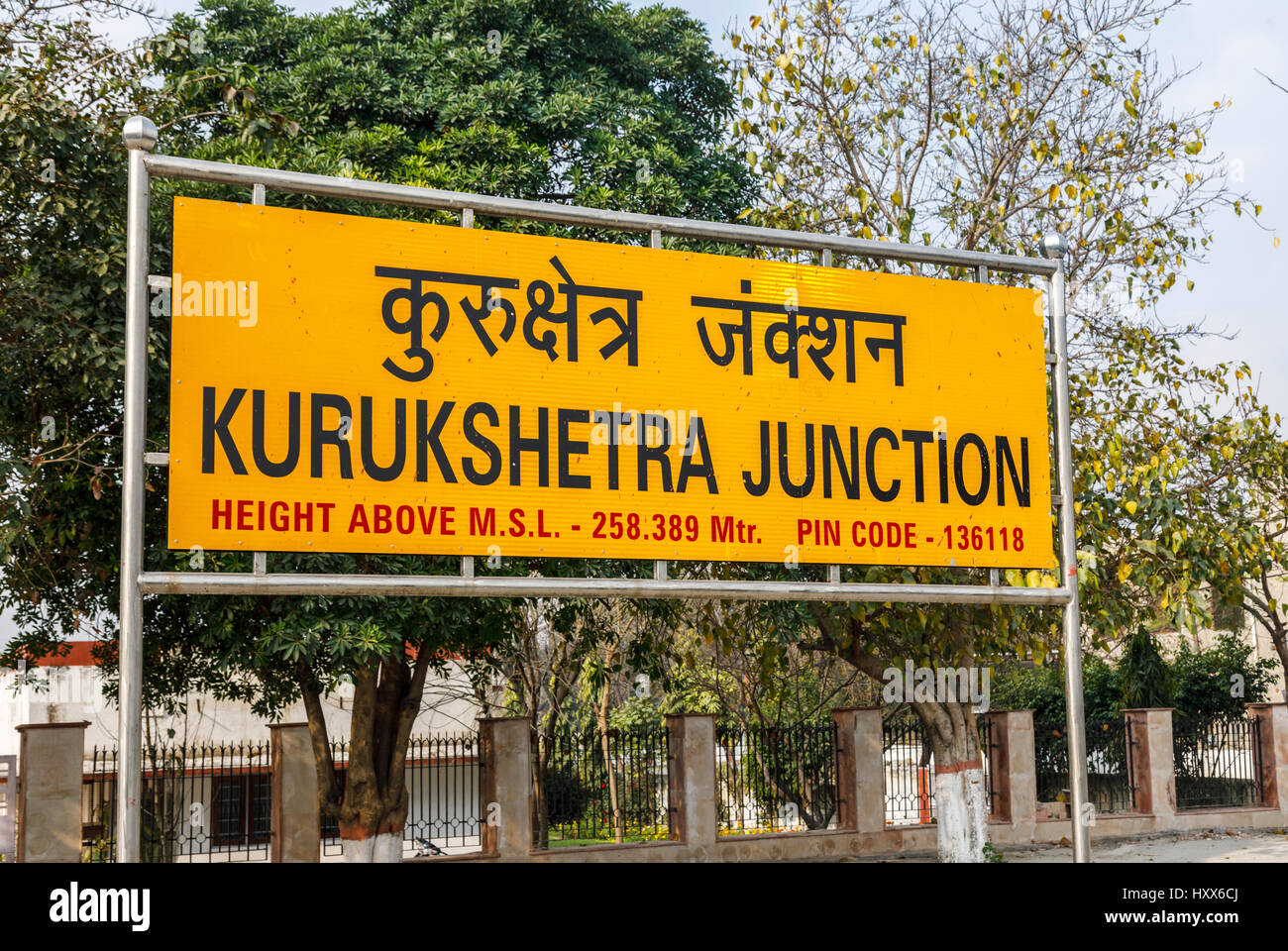 Tipici giallo nome sign sulla piattaforma a Kurukshetra giunzione stazione ferroviaria piattaforma, su Delhi a Kalka linea, Haryana, l'India del nord Foto Stock